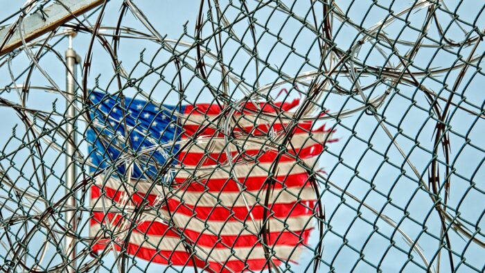 The US flag behind barbed wire
