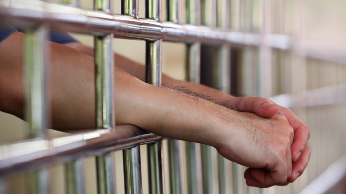 Hands through cell bars